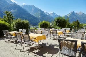 a group of tables and chairs with mountains in the background at Gasthof Gröbenhof in Fulpmes