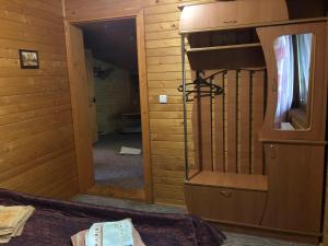 Una habitación con espejo y una cama en una habitación en Skarbivka en Vorokhta