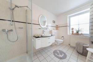 a bathroom with a shower and a sink and a toilet at NTBM36001-Binnenseeblick in Neue Tiefe Fehmarn +13 photos