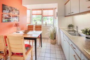a kitchen with a table and a sink at NTBM36001-Binnenseeblick in Neue Tiefe Fehmarn