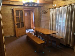 a dining room with a table and benches in a cabin at Skarbivka in Vorokhta