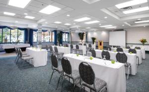 a conference room with white tables and chairs and a whiteboard at Lake Louise Inn in Lake Louise +37 photos