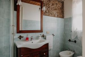 uma casa de banho com um lavatório e um WC em La Baronessa B&B em Riposto