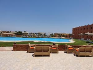 a group of chairs sitting in front of a pool at Fanar Hotel in Ain Sokhna