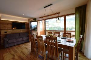 a dining room with a table and chairs and a couch at Ciasa Lisüra in Badia