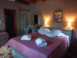 Un dormitorio con una cama rosa con toallas. en Foris House, en Vikos