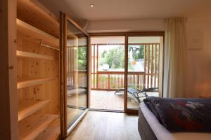 a bedroom with wooden walls and a sliding glass door at Ciasa Lisüra in Badia
