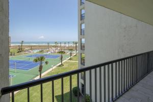 uma varanda de um edifício com dois campos de ténis em Saida em South Padre Island