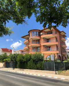 un edificio de apartamentos naranja al lado de una carretera en Guest House Val and Kate, en Sveti Vlas