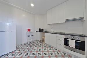 a kitchen with white appliances and a tile floor at Sleep in Centre in Porto