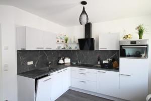 Küstenliebe 8 في غرال موريتز: مطبخ بخزائن بيضاء وطاولة عمل سوداء +38 صورة