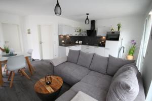 Küstenliebe 8 في غرال موريتز: غرفة معيشة مع أريكة رمادية وطاولة