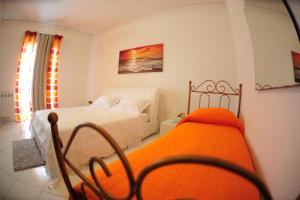 a bedroom with a bed with an orange blanket at The Last Floor in Torre del Greco