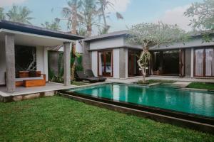 a swimming pool in the backyard of a house at Anggira Villa Ubud in Ubud
