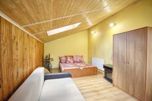 ein Schlafzimmer mit einem Bett und einem Sofa in einem Zimmer in der Unterkunft Poilsis Pas Tada in Druskininkai