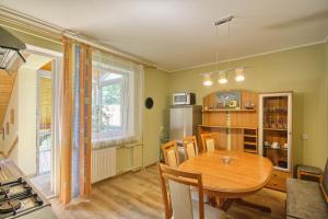 a kitchen and dining room with a wooden table at Poilsis Pas Tada in Druskininkai