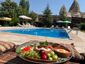 a tray of fruit on a table next to a pool at Kufe Hotel in Goreme