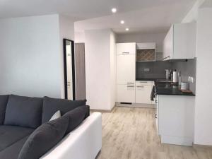 een woonkamer met een bank en een keuken bij Appartement Studio Agrita in Wittisheim
