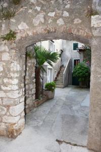 une arche dans un bâtiment en pierre avec un escalier dans l'établissement Apartman Marko Cres, à Cres