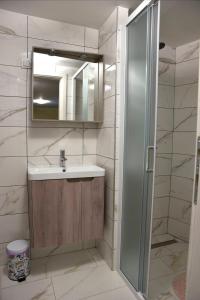 a bathroom with a sink and a mirror and a shower at Apartman Marko Cres in Cres +9 photos