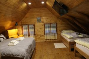 Un dormitorio con dos camas en una cabaña de madera. en Holiday Home Lina, en Pleškovec