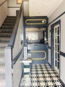 a staircase in a building with a black and white tiled floor at The Traxx Hotel in Bangor