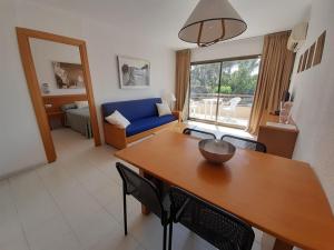 パルスにあるAparthotel Golf Beachのテーブルと青いソファのあるリビングルーム