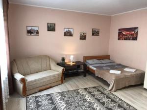 a bedroom with a bed and a couch and a chair at Apartment near the Forum mall in Lviv