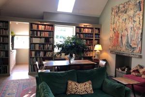 uma sala de estar com um sofá verde e prateleiras de livros em Barns Library em Peebles