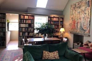 a living room with a green couch and book shelves at Barns Library in Peebles