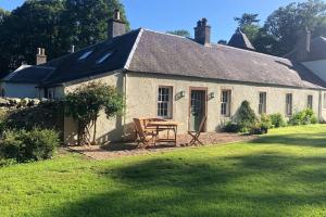 a white house with a picnic table in front of it at Barns Library in Peebles