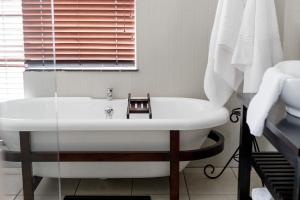 bagno con vasca bianca e finestra di Wagtails Guest House a Port Elizabeth