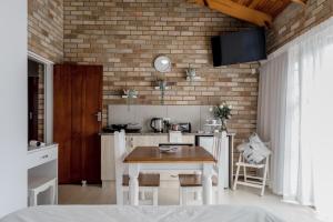 a kitchen with a table and a brick wall at Wagtails Guest House in Port Elizabeth