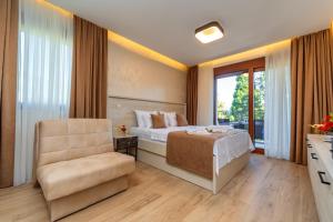 ein Schlafzimmer mit einem Bett, einem Stuhl und einem Fenster in der Unterkunft Luxury Apartments Queen in Petrovac na Moru