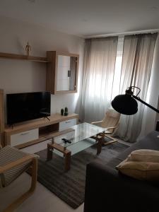 uma sala de estar com uma televisão de ecrã plano e uma mesa em El RiNCoNCiTo De Su em Gijón