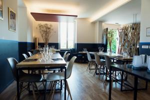 a row of tables in a restaurant with chairs at Hotel Restaurant La Musardiere in Giverny