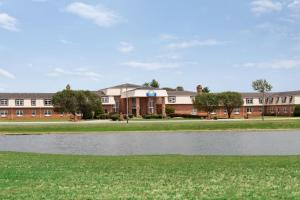 un edificio con un estanque delante de él en Days Inn and Suites by Wyndham Sikeston, en Sikeston