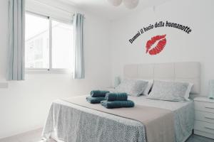 biała sypialnia z łóżkiem z 2 poduszkami w obiekcie Carlito HolidayFV w Corralejo