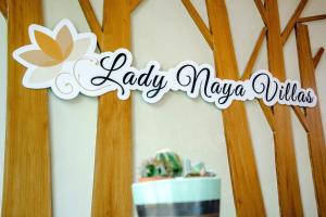 拉威海灘的住宿－Lady Naya Villas - SHA Extra Plus，一张桌子旁的女柳条标语