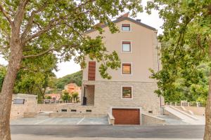a building with a tree in front of it at Luxury Apartments Queen in Petrovac na Moru