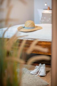 een hoed en een paar schoenen naast een bed bij Strandkorb in Fehmarn