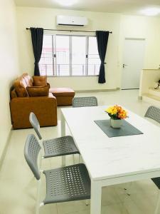 sala de estar con mesa blanca y sillas en Impact MT House en Ban Bang Phang