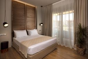 a bedroom with a large bed and a large window at Costa D' Ifesto in Agios Ioannis Kaspaka