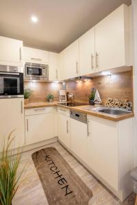 a kitchen with white cabinets and a sink at Strandkorb in Fehmarn