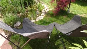 zwei Stühle im Gras im Garten in der Unterkunft K82 BNB & Hotel in Kirchentellinsfurt