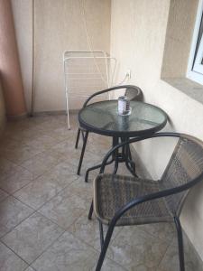 a table with two chairs and a cup on it at Къща за гости Aтанасов II in Primorsko