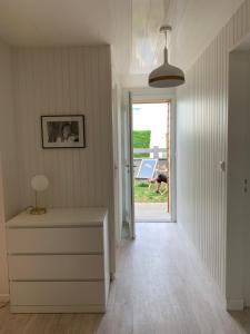 een hal met een dressoir en een deur met een persoon buiten bij La Maison de Juliette in Agon Coutainville