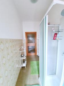 a bathroom with a walk in shower next to a door at Affittacamere Zona Caserma-Stazione in Foligno