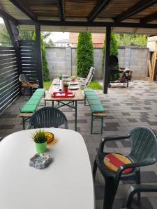 a patio with tables and chairs on a patio at Honfoglalas Apartment in Bük