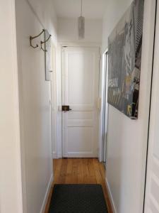 einen Flur mit einer weißen Tür und einem schwarzen Teppich in der Unterkunft Appartement SAINTE ELISABETH - République in Paris
